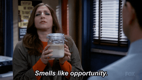 A woman holding sourdough starter and saying, "Smells like opportunity."