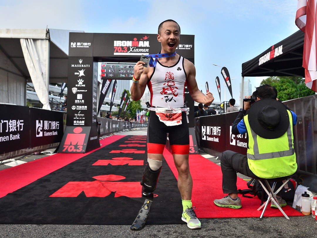 Photo: IRONMAN 70.3 Xiamen participant posing with his medal after the race.t